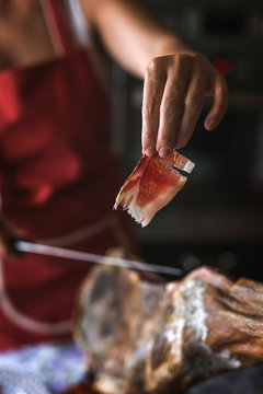 Unrecognizable woman slicing sliced ham