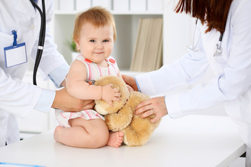 Happy cute baby  at health exam at doctor's office. Medicine and health care concept
