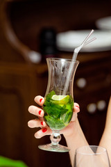 Woman holding cocktail in her hand