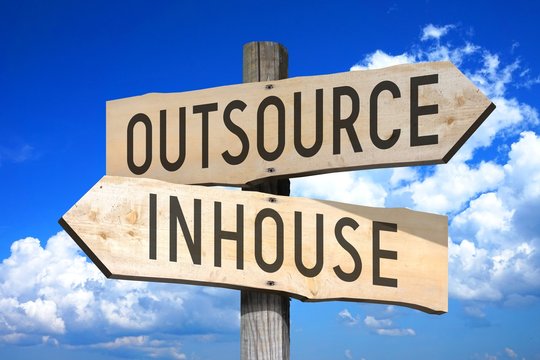 Outsource, inhouse - wooden signpost