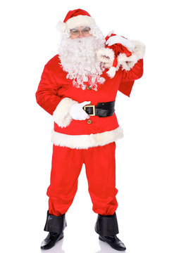 Santa Claus standing with his sack full of presents, isolated on white background. Full length portrait