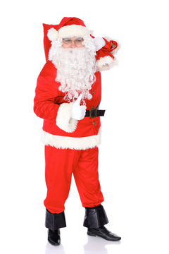 Santa Claus standing with his sack full of presents, isolated on white background. Full length portrait