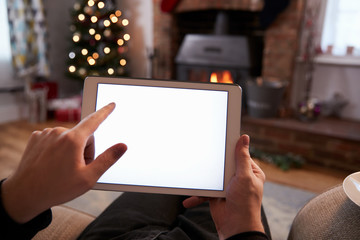 Man Using Digital Tablet In Room Decorated For Christmas