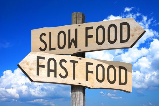 Slow food, fast food - wooden signpost