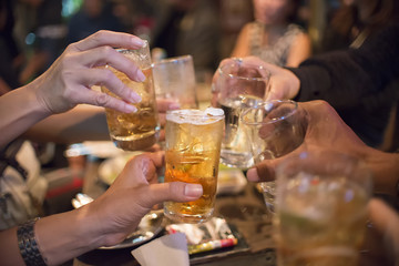 People holding beer glass, drinking cocktail together at bar,