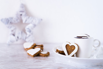 Fototapeta na wymiar biscotti a forma di cuore e tazza con cioccolata alla panna. Foto orizzontale 