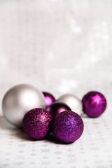 Purple Sparkling and Silver Christmas balls Close-up on a soft focus light background. Vertical holiday banner with copy space