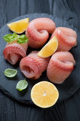 Close-up of marinated tilapia fish fillet rolls, selective focus