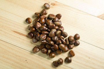 Chestnuts on pine wood background.