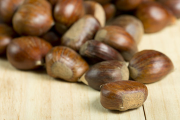 Chestnuts on pine wood background.