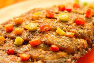 Grilled carp gourami fish with herbs tomatoes cucumber and chili pepper 