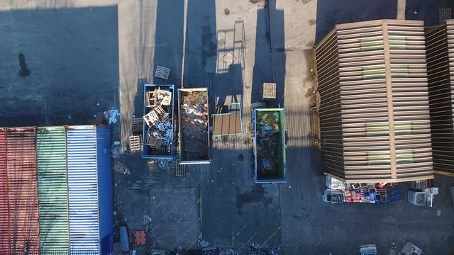 Rising aerial shot of recycling bins and an industrial area.