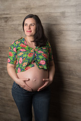 Pregnant woman in jeans at the wall