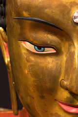 Tibetan Buddha golden sculpture face close up