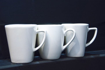  white cups on the black shelf