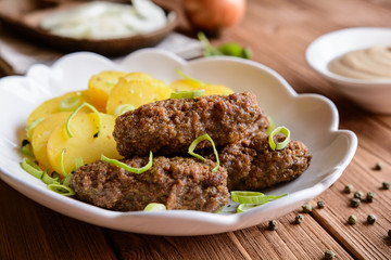 Cevapcici made of minced meat with potato, leek and onion