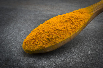 dust of ground turmeric on the grey background