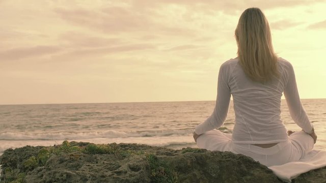 practice of yoga on the beach: woman having meditation moments, spiritual time
