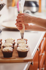 Confectioner decorates a cupcake