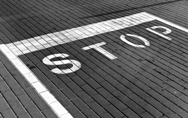 Stop sign on pavement in black and white