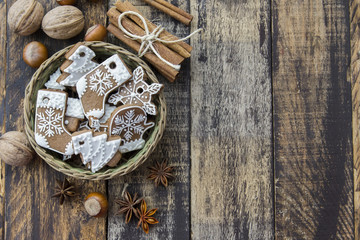 Basket with ginger cookies, nuts and cinnamon on dark wooden background