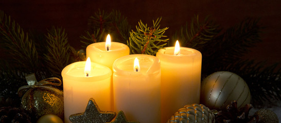 Four burning advent candles and Christmas decoration.