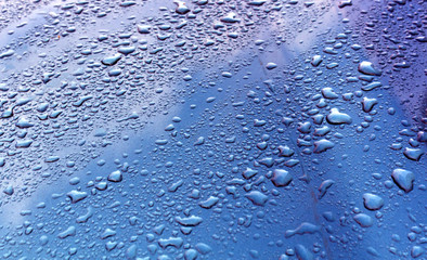 Rain drops on blue metal surface.