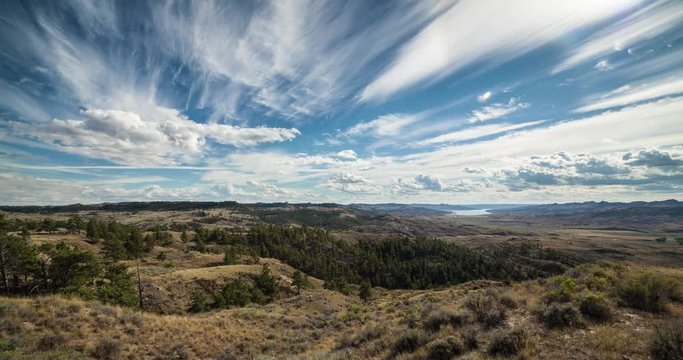 Timelapse couds over prairie breaks leading to lake
