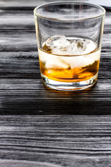 glass of whiskey on dark wooden background