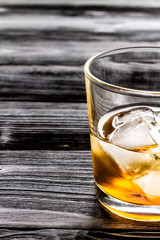 glass of whiskey on dark wooden background
