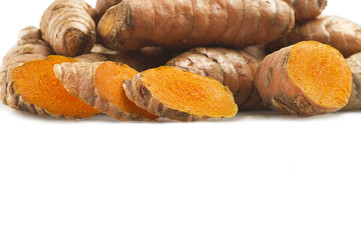 turmeric root and some slices on a white background