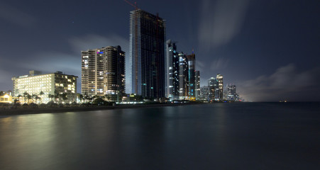 City at night in front of the ocean