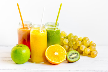 Fresh detox juices in glass bottles on white background
