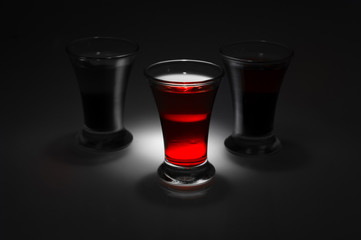 red and tow shot glass on a dark background in the spot light