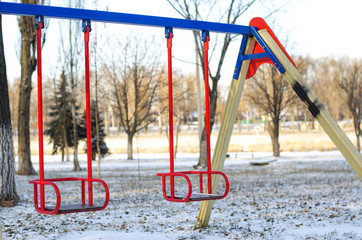 Fototapeta na wymiar Children's swing in a park in winter