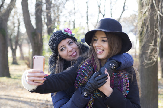 Two young business women photographed mobile phone
