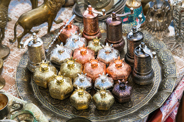 Fototapeta na wymiar Old oriental antiques barass sugar bowl and caffee grinder on a tray in Baku city, Azerbeijan.
