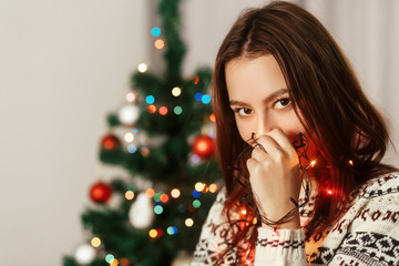 Beautiful sensual brunette woman in white reindeer sweater holdi