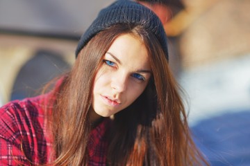 Portrait of a beautiful serious teen girl with blue eyes, wearing a red shirt and hat.