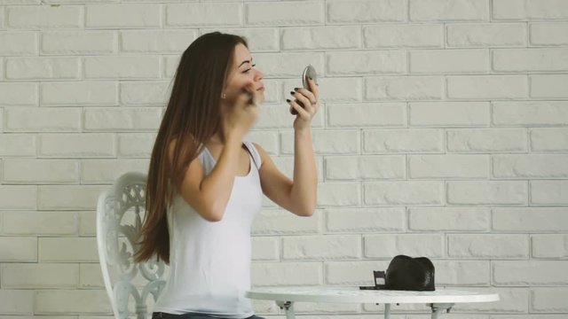 Young adult woman doing makeup by herself