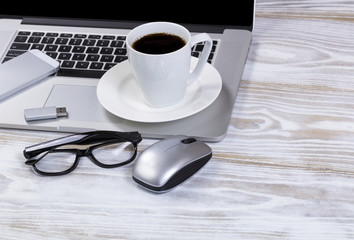 Cup of dark coffee with portable work devices on rustic desktop 