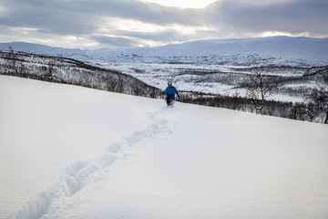 Snowy mountain lanscape with a child walking, Nordland, Norway