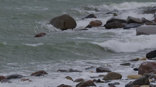 Slow motion - scenic waves breaking on rocky arctic beach in storm