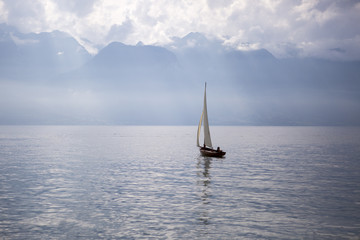 landscape of the Geneva lake  with a boat sailing and the Alps mountains in the background - Vevey, Switzerland