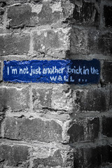 message painted on a brick of a wall: I am not another brick in the wall
