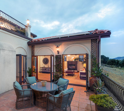 Courtyard Of Mediterranean Home With Seating Leading Into Living Room. 