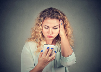 annoyed young woman, pissed off by what she saw on her cell phone - obrazy, fototapety, plakaty