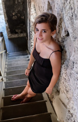 Pretty hispanic teenage girl standing on an old wooden staircase
