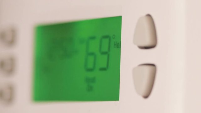 Digital thermostat used for heating and cooling - Energy expense and finance concept