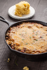 Homemade chili baked in cast iron skillet with side of cornbread